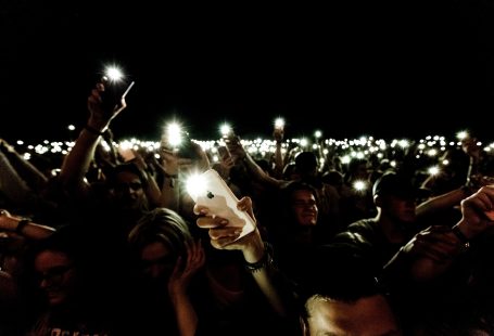 person holding phones with turned on flashlights